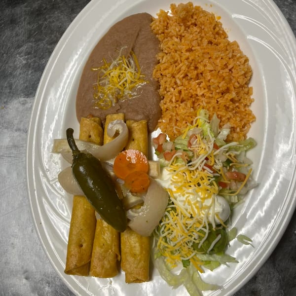 A Primos De Tico's Mexican plate with taquitos, refried beans, rice, salad, and a jalapeño.